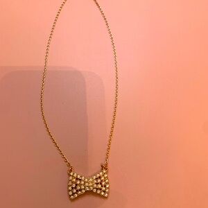 Stylish rose-gold colored Kate Spade classic bow necklace.